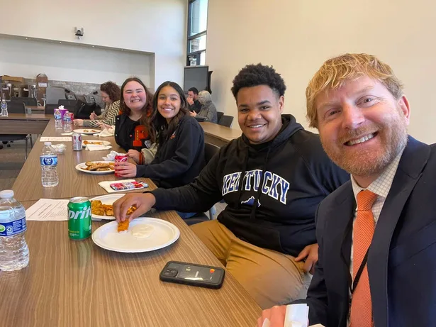 Stephen McCauley sitting with students in a school setting